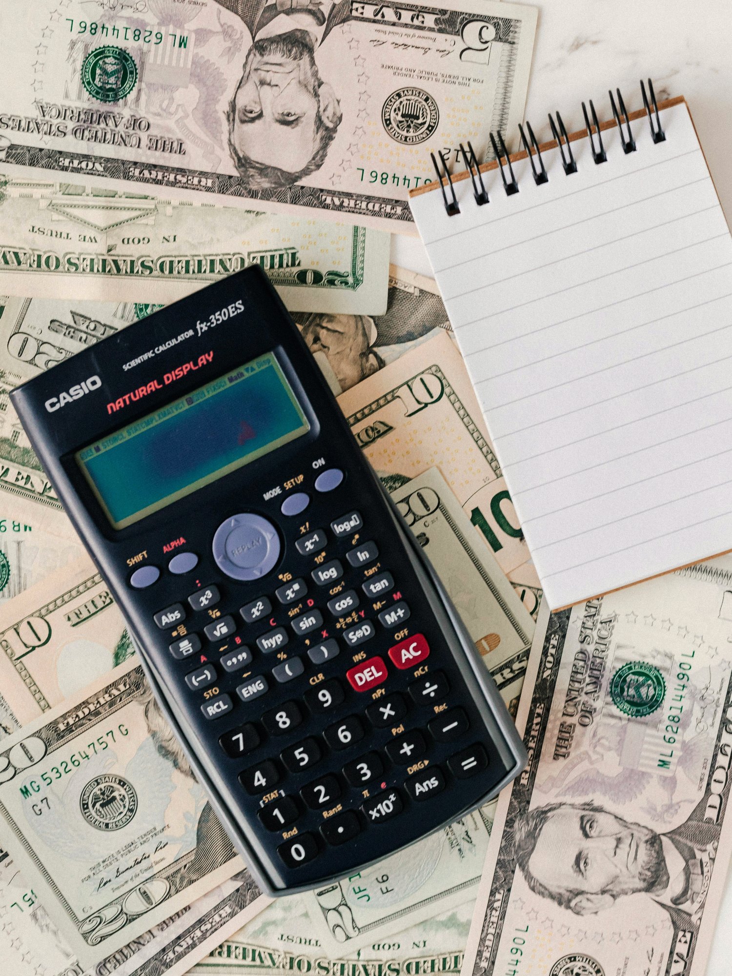 Foto de una calculadora y un anotador.